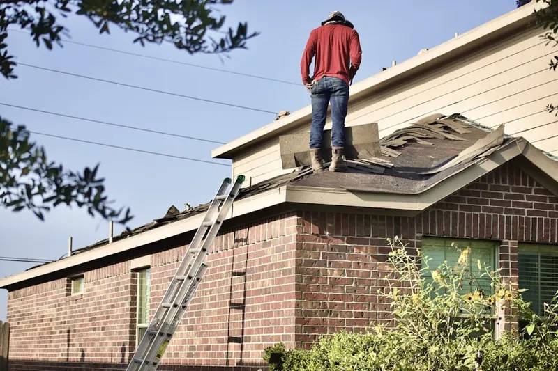 Professional roofer working on a residential roof in Longport